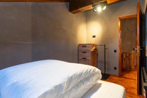Pleta del Tarter Lodge في التارتر: غرفة نوم بسرير ابيض وخزانة