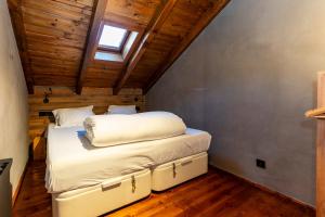 a bed in a room with a vaulted ceiling at Pleta del Tarter Lodge in El Tarter