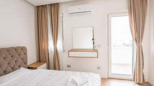 um quarto branco com uma cama e uma janela em Premium Apartment in the Center em Tirana