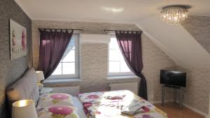 a bedroom with a bed and a tv and windows at Blumen Apartment in Hamburg