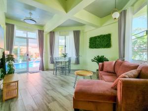 a living room with a couch and a table at Tina's Living Paradise II - Guesthouses with private pool, 5 min to beach in Rayong