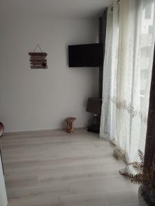 une pièce blanche avec une télévision et une fenêtre dans l'établissement studio avec piscine, à Gruissan