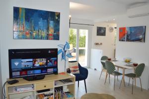 sala de estar con TV y mesa con sillas en La Bastide, 100m des rues piétonnes, jardin en Sanary-sur-Mer