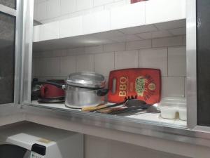 - un comptoir de cuisine avec des casseroles et des poêles sur une cuisinière dans l'établissement kit próximo da praia, à Praia Grande