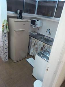 Elle comprend une petite cuisine équipée d'un réfrigérateur et d'un évier. dans l'établissement kit próximo da praia, à Praia Grande
