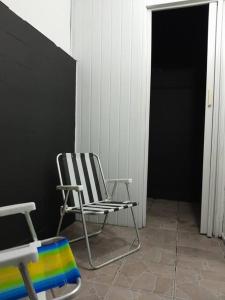 une chaise noire et blanche assise dans une pièce dans l'établissement kit próximo da praia, à Praia Grande