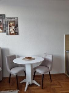 einen weißen Tisch und zwei Stühle in einem Zimmer in der Unterkunft Mrakovica 1 in Prijedor