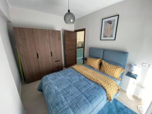 um quarto com uma cama com um edredão azul em Callisto skg em Tessalônica