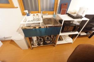um balcão de cozinha com um lavatório e uma máquina de lavar louça em Family Home Shimanouchi House Ⅱ em Osaka