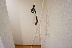 uma escada com dois ganchos na parede em Family Home Shimanouchi House Ⅱ em Osaka