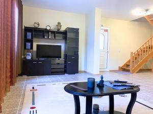 a living room with a table and a television at Santana House - Holiday Rental by Your Key in Santana