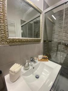 uma casa de banho com um lavatório branco e um espelho. em Testaccio, Alessandro Volta, camera indipendente em Roma