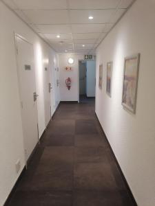 un corridoio con pareti bianche e pavimento piastrellato di SUN1 BLOEMFONTEIN a Bloemfontein