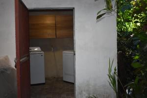 a bathroom with a toilet and a washer and dryer at Casita Flor de Loto in Puerto Viejo