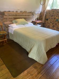 Schlafzimmer mit einem großen Bett mit einem Kopfteil aus Holz in der Unterkunft Eco hause Ollantaytambo in Ollantaytambo