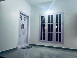 a white room with two doors and a tile floor at PONMUDI VILLA in Ambalavayal