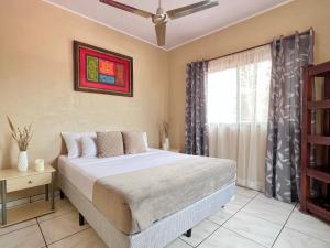 a bedroom with a bed and a window at Casa Tatich AC near Guanacaste Airport in Liberia