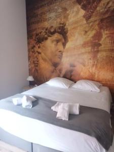 een bed met een schilderij aan de muur bij Suite PREMIUM LE FIGARO 1 in Épernay