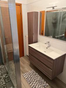 a bathroom with a sink and a shower with a mirror at La casa al mare in Policoro