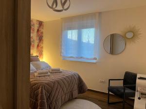 a bedroom with a bed and a mirror and a window at Apartman Bono in Sinj