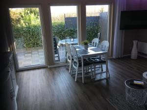 a dining room with a table and chairs and a balcony at Ferienwohnung drei Eichen in Isernhagen