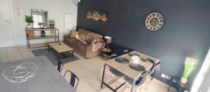 ein Wohnzimmer mit einem Sofa und einem Tisch in der Unterkunft Superbe appartement en résidence avec piscine. in Albertville
