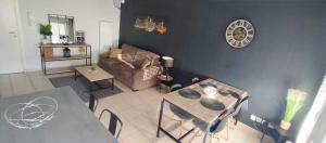 a living room with a couch and a table at Superbe appartement en résidence avec piscine. in Albertville