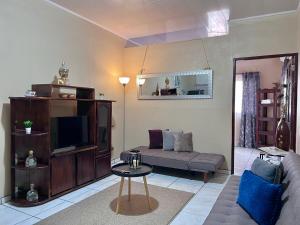 sala de estar con sofá y TV en Casa Tatich AC near Guanacaste Airport en Liberia