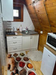 eine Küche mit vielen Schüsseln Essen auf dem Boden in der Unterkunft VILA MAGDA in Divčibare