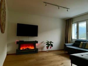 sala de estar con chimenea y TV de pantalla plana en WEF DAVOS PLATZ Centre 3,5 Apartment with Garage, en Davos