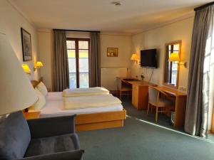 a hotel room with a bed and a desk at Gasthof Hummel Hotel 