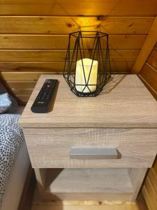 a nightstand with a candle and a remote control on it at VILA MAGDA in Divčibare