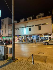 una strada di città di notte con auto parcheggiate sulla strada di APARTMAN PAVIĆ a Vinkovci