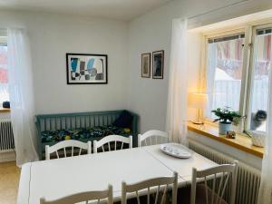 a dining room with a white table and chairs at Lägenhet i lugn trädgård in Bygdeå