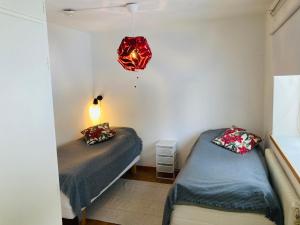 a bedroom with two beds and a chandelier at Lägenhet i lugn trädgård in Bygdeå