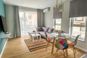 sala de estar con sofá, mesa y sillas en "The House" Апартаменти и Термална зона, en Velingrad
