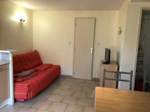 - un salon avec un canapé rouge et une télévision dans l'établissement Le Serre, à Millau