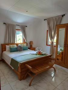 a bedroom with a large bed and a mirror at Lucy's guesthouse in La Digue