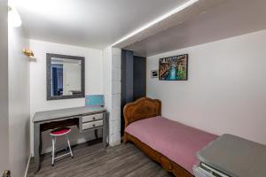 1 dormitorio con cama y escritorio con espejo en Superbes appartements en Mimizan