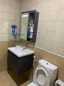 a bathroom with a toilet and a sink and a mirror at Ramble Stay Hostel in Dubai