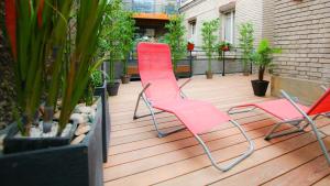 ランスにあるREIMS-ESCAPADE terrassesの植物のあるデッキに座るピンクの椅子2脚