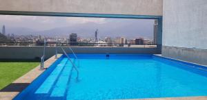 a large swimming pool on the roof of a building at Familiar en el centro de Santiago 16 B in Santiago