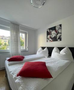 a bedroom with two beds with red and white pillows at Wohnung See- und Bergnähe in Gmunden