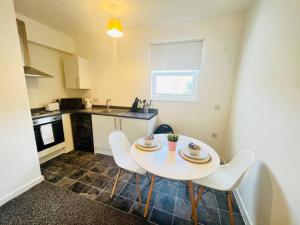 a kitchen with a table and chairs in a kitchen at Comfy Stylish 1BD Apt near Transport Links in Liverpool