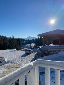 une voiture garée devant un kiosque dans la neige dans l'établissement SevenHills chalet, à Yablunytsya