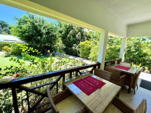 a porch with a table and chairs on a balcony at Lucy's guesthouse in La Digue