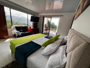 a bedroom with a bed with a couch and a window at finca hotel luzsagra in La Vega