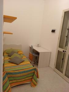 1 dormitorio con cama, escritorio y escritorio en MaryAlex en Punta Secca