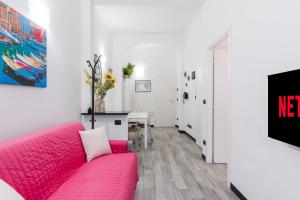 a living room with a pink couch and a table at ACQUARIO 5 Minuti, FREE A-C, Wifi & Netflix ''City Center'' by TILO in Genova