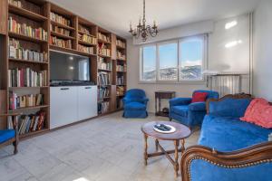 - un salon avec un canapé, une télévision et des étagères dans l'établissement Vue panoramique, grand appartement 2 chambres à Toulon, à Toulon